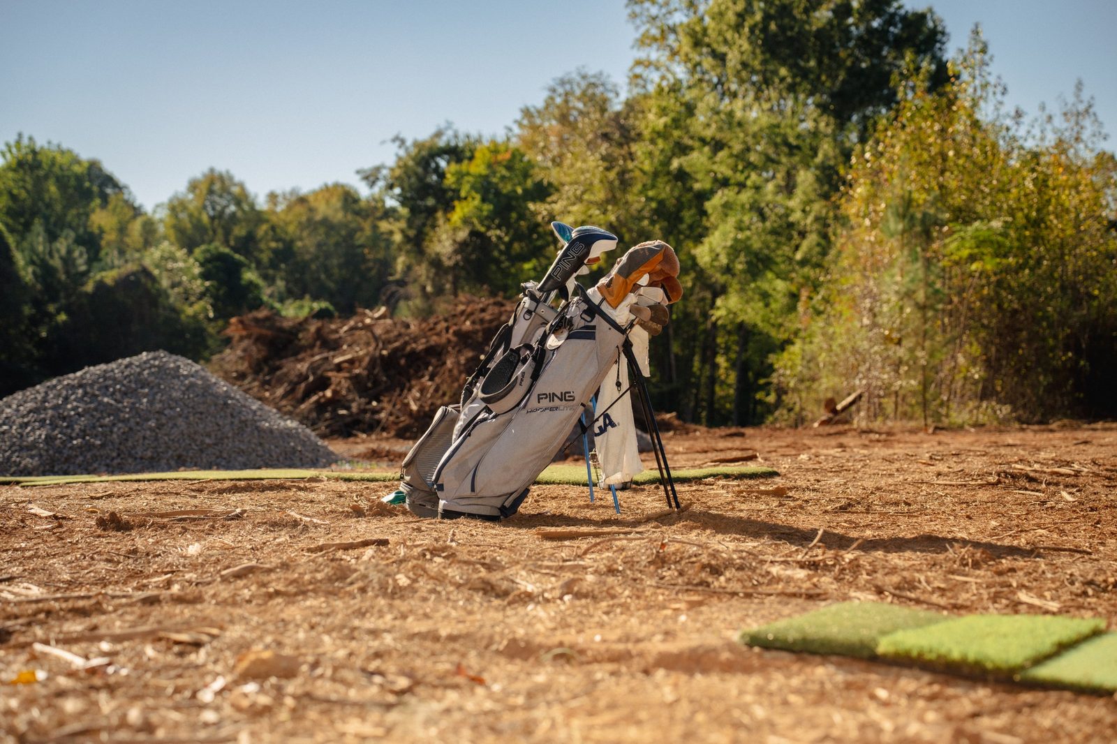 A golf bag standing on bare construction ground